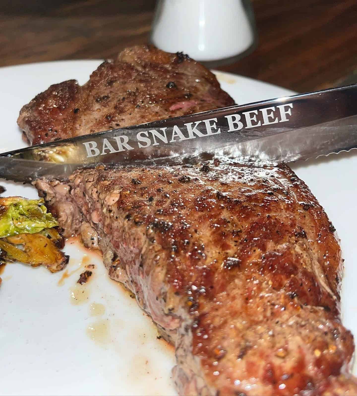 Juicy grilled steak with seasoning and grill marks on a white plate for liberty-themed dining.