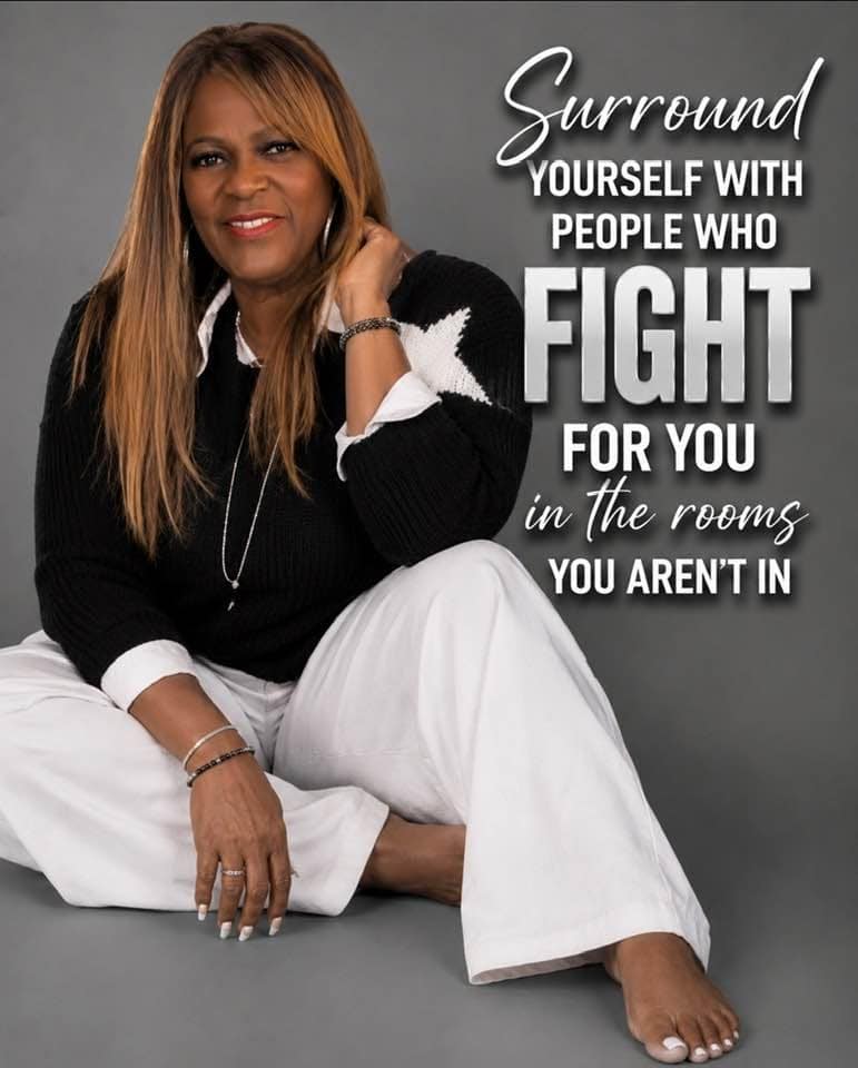 Woman sitting cross‑legged in a black sweater and white pants, with a motivational quote about surrounding yourself with supporters on the right side.